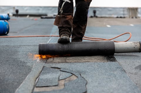 Professional roofer securing tar paper