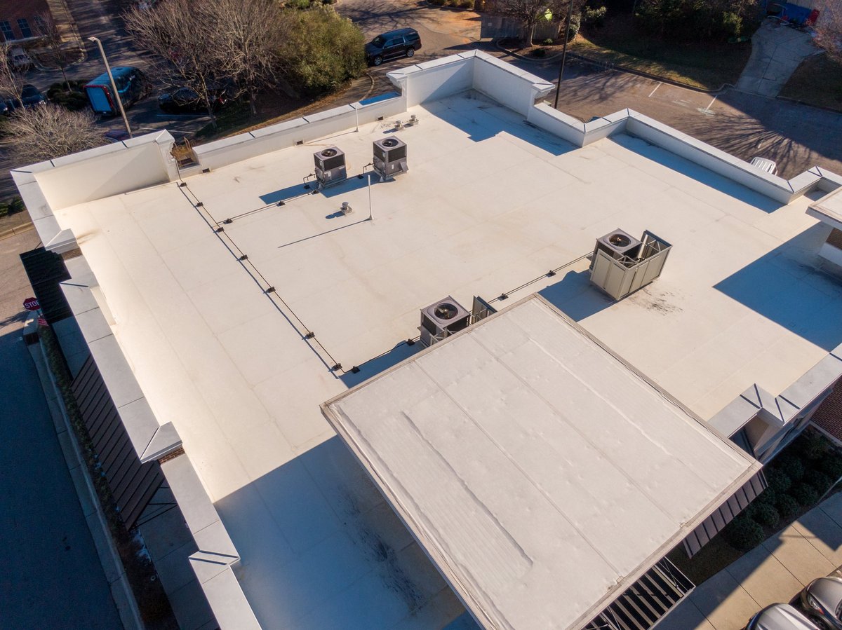 Drone aerial images showing a variety of commercial and industrial buildings with white TPO flat roofing systems